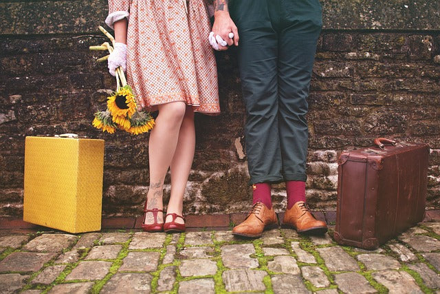 Couple holding hands with luggage, walking through a scenic Canadian destination, symbolizing romantic getaways in Ontario and Quebec