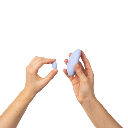 Two hands holding small purple devices against Lay Panty Vibrator
