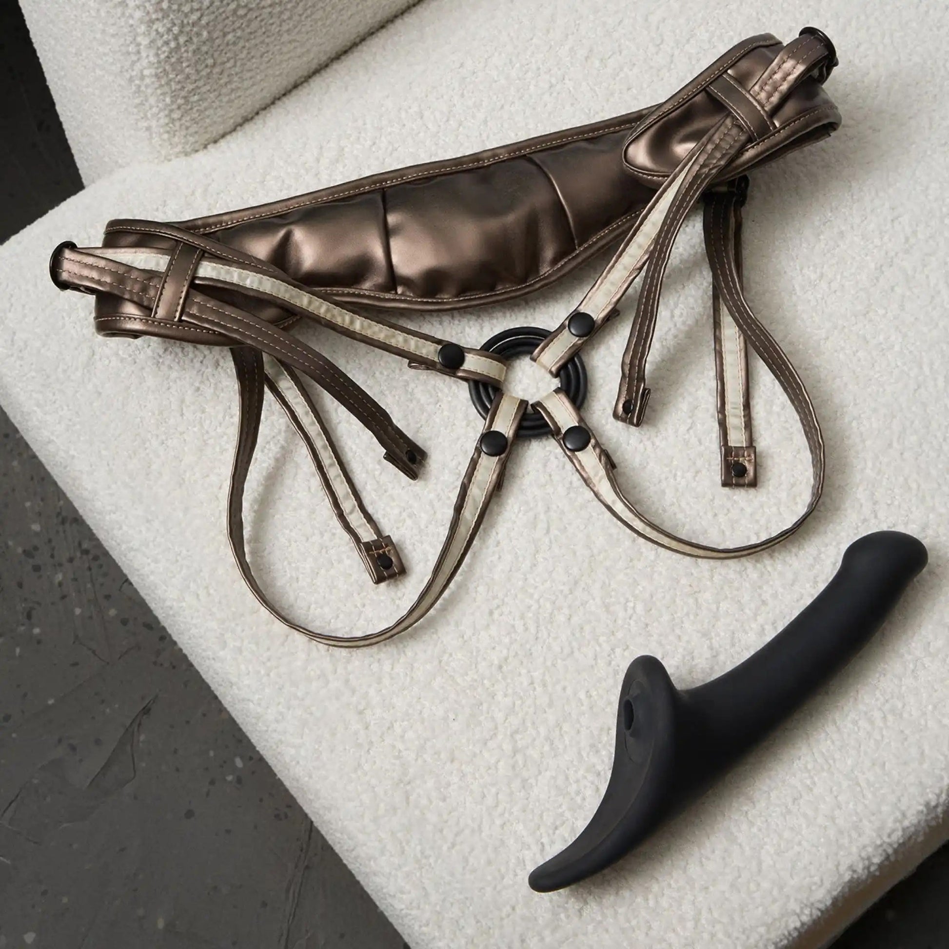 Brown leather harness with black附件 on a textured surface
