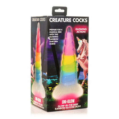 Packaged rainbow silicone dildo with 'Creature Cocks Uni-Glow - Glow-in-the-Dark Rainbow Unicorn Horn Dildo' branding on a white background