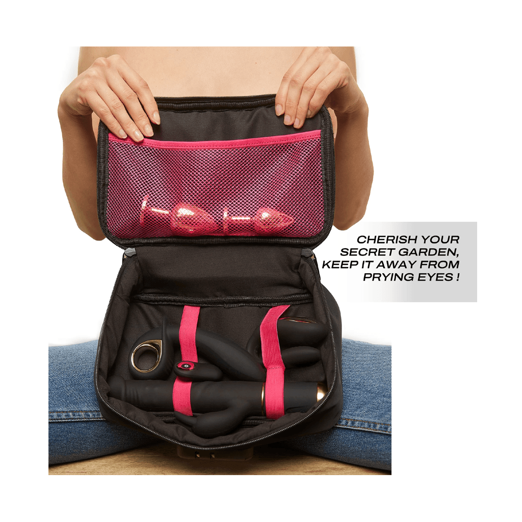 Black toiletry bag with pink accents held open by a person, showing items inside.